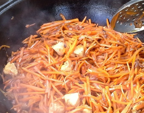 1. Этап. Плов из индоутки: Сверху кладём морковь. Если недостаточно жира и сока из индоутки, можно добавить кипящей воды, чтобы жидкость покрывала морковь. На сильном огне довести до кипения, затем немного убавить огонь и томить около 15 минут, помешивая. Далее добавить специи для плова, соль и томить ещё 15 минут.