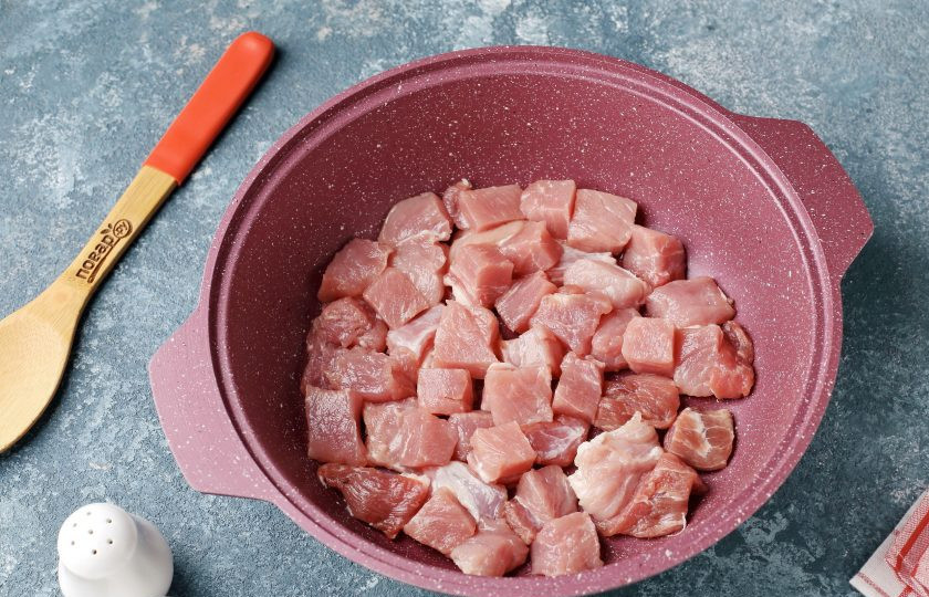 1. Этап. Мясо с квашеной капустой по-немецки: Подготовьте казан или любую посуду с толстым дном. Выложите нарезанное небольшими кусочками мясо.