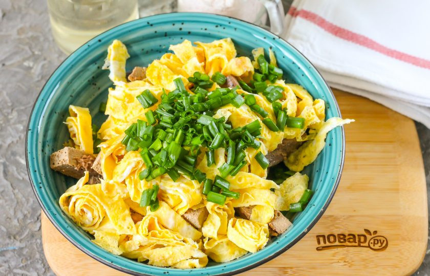 1. Этап. Салат Омлетный: Промойте зеленый лук, измельчите и добавьте в емкость. По желанию можно использовать маринованный репчатый лук и другую свежую зелень: укроп, петрушку, сельдерей.