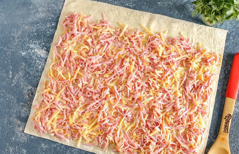 1. Этап. Ленивые пирожки с начинкой: Лаваш смажьте майонезом и посыпьте начинкой, немного отступив от одного края.