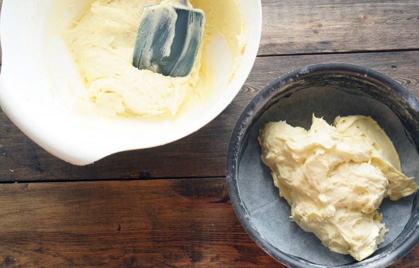 1. Этап. Масляный бисквит: Смажьте форму сливочным маслом и присыпьте мукой, застелите дно пергаментом. Выложите тесто (оно получается очень густым), разровняйте его лопаточкой.