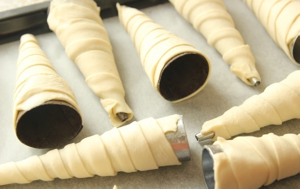 1. Этап. Слоеные трубочки с белковым кремом: Специальные формочки в виде конусов смажьте растопленным сливочным маслом. Аккуратно, спиралью оберните каждую форму полоской теста.