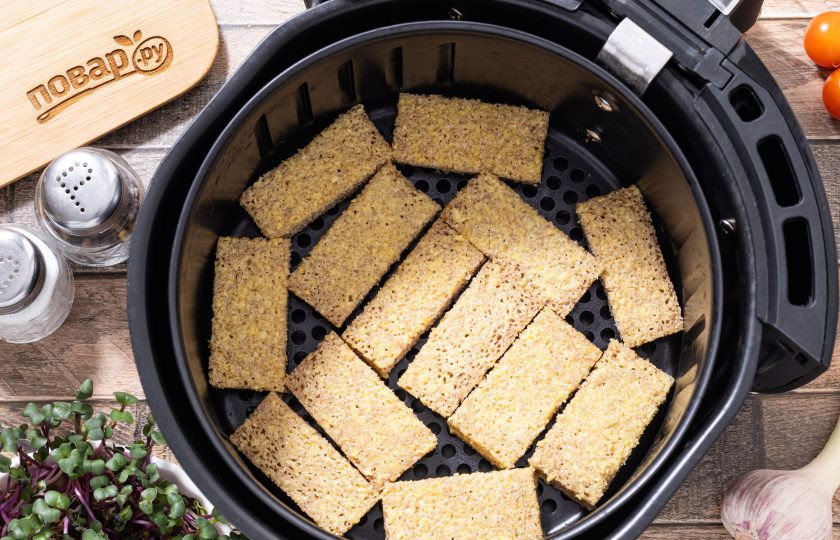 1. Этап. Гренки в аэрогриле: Выложите брусочки хлеба в один слой на решетку или в корзинку аэрогриля. Готовьте 5-7 минут при температуре 160 градусов до румяной корочки.