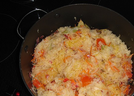 1. Этап. Бигус с фасолью: Наливаем в кастрюлю растительное масло и выкладываем в нее тертую морковь и корень петрушки, измельченный лук, жарим овощи до золотистого цвета. Затем отжимаем квашеную капусту и также отправляем ее на сковороду, продолжаем все жарить еще пару минут. Потом добавляем нарезанные на небольшие кусочки помидоры и лавровый лист, вливаем в кастрюльку совсем немного водички. Накрываем все крышкой и тушим на медленном огне 20 минут.