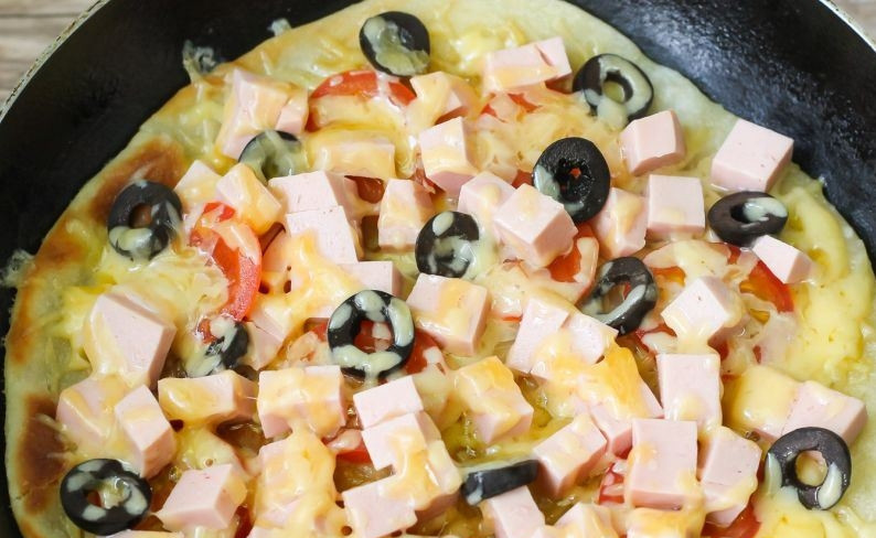 1. Этап. Домашняя пицца на тонком тесте: Присыпьте пиццу остатками сыра. Накройте сковороду крышкой и поджаривайте на медленном огне десять минут, чтобы сыр расплавился, а корж подрумянился.