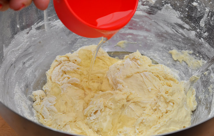 1. Этап. Пирожки с рыбой: 4. Когда тесто начнет густеть, добавить растительное масло и продолжать вымешивать, подсыпая муку.