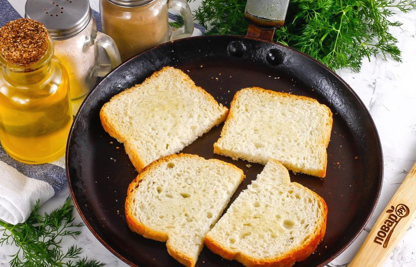 1. Этап. Брускетты с печенью трески: Ломтики хлеба разрежьте пополам диагонально, вертикально или горизонтально — по желанию. Смажьте их растительным маслом и поджарьте на сухой сковороде с обеих сторон до румяности. Затем выложите на тарелку и дайте остыть в течение 5 минут, чтобы они стали хрустящими.