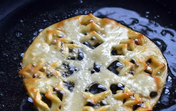 1. Этап. Исландский рождественский хлеб: В глубокой сковороде разогрейте растительное масло. Обжарьте заготовку с одной стороны в течение нескольких секунд, аккуратно переверните с помощью двух лопаток и обжарьте с другой стороны.