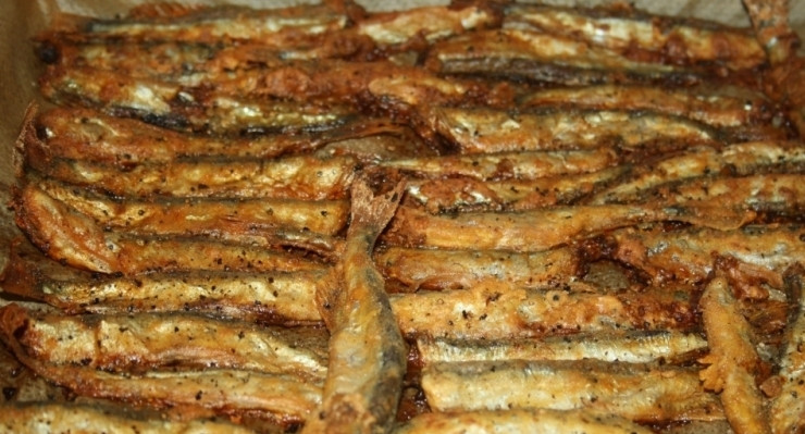 1. Этап. Мойва, жареная в духовке: Рыбу уложите на противень с пергаментной бумагой. Старайтесь выкладывать одним слоем. Запекайте её в течение 10-15 минут при температуре 200 градусов.