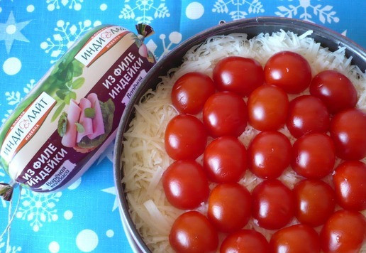 1. Этап. Салат к Новогоднему столу: На слой натертого сыра я сразу выложила помидоры черри разрезанные на половинки, отступив немного от края.