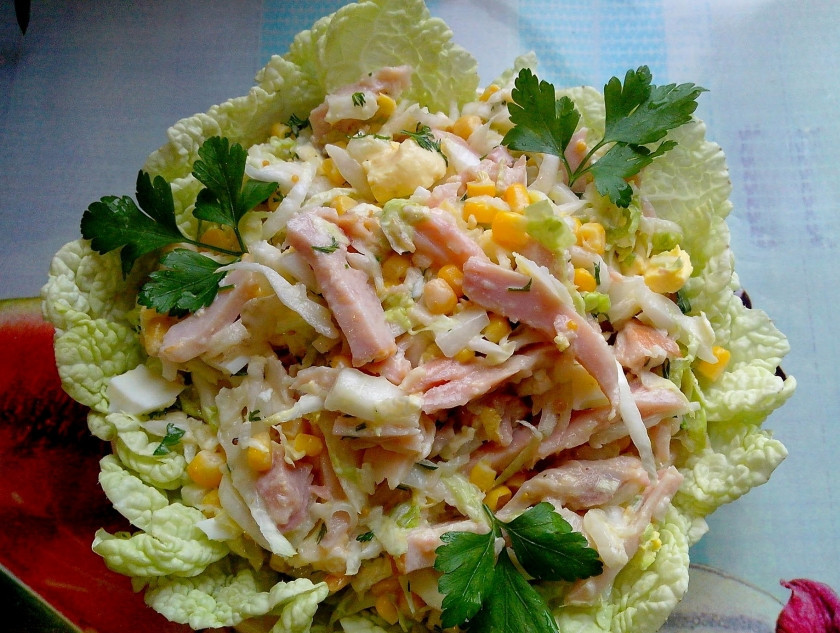 1. Этап. Салат с копченой курицей и кукурузой: Теперь берем тарелочку и оформляем салат. Кладем вниз листья пекинской капусты. Сверху помещаем на них несколько ложек салата. Украшаем петрушкой или любой другой зеленью. Блюдо готово!