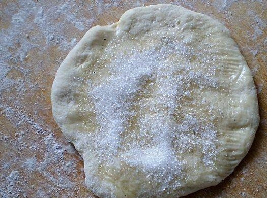 1. Этап. Булочки из дрожжевого теста с сахаром: 4. Разделяем его на небольшие кусочки, раскатываем круг небольшого диаметра, смазываем его подсолнечным маслом и посыпаем сахаром.