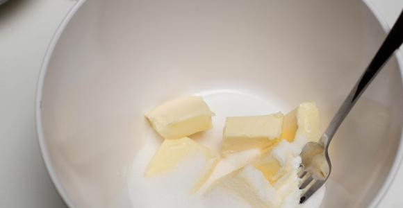 1. Этап. Королевский творожный пирог: 1. В глубокую мисочку отправьте размягченное сливочное масло и половину сахара. Разомните вилкой.