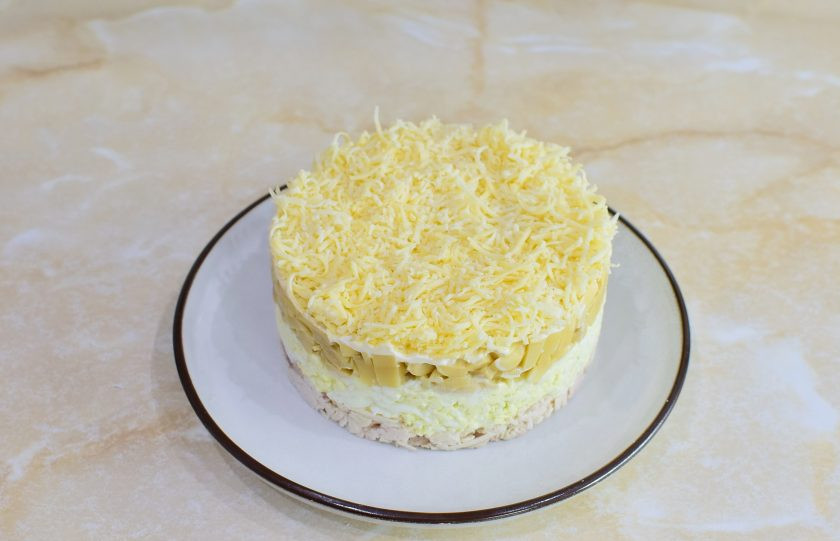 1. Этап. Салат с курицей, сыром и маринованными грибами: Последним слоем салат выложите сыр, натертый на терке. Снимите сервировочное кольцо и поставьте салат в холодильник, чтобы все ингредиенты стали одной температуры.