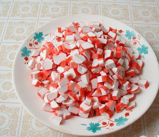 1. Этап. Салат с крабовыми палочками Весёлый краб: 4. Теперь очищаем от целлофана крабовое мясо или крабовые палочки, и кусочками нарезаем: каждую палочку разрезаем вдоль части на две или на четыре, а потом нарезаем поперек.