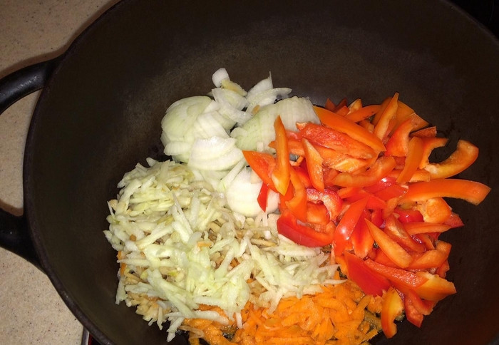 1. Этап. Аджика из помидоров и лука на зиму: В казане разогреваем растительное масло. Обжариваем морковь, перец, лук и яблоки. Примерно 20 минут, помешивая.