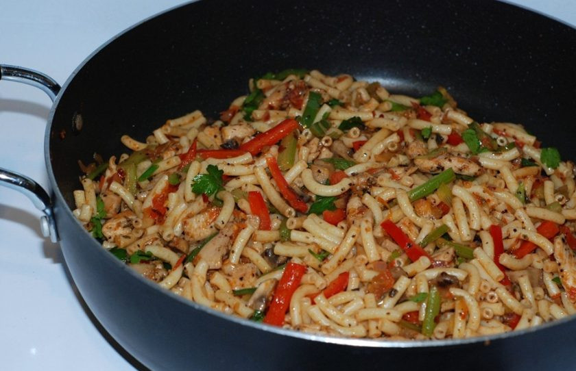 1. Этап. Острые макароны с курицей и овощами: 3. Смешайте свареные макароны с мясом и обжаренными овощами. Посолите и поперчите по вкусу. Добавьте нарезанную петрушку и перемешайте.