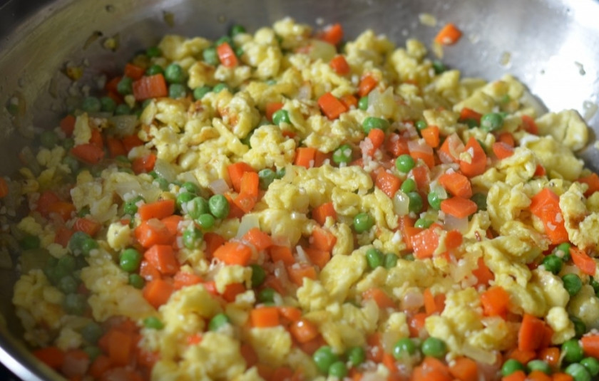 1. Этап. Рис с морковкой и луком на сковороде: 3. Через пару минут можно добавить щепотку соли (при желании можно и перец) и активно все перемешать. Выложите на сковороду также зеленый горошек. Оставьте жариться еще около 3-5 минут.