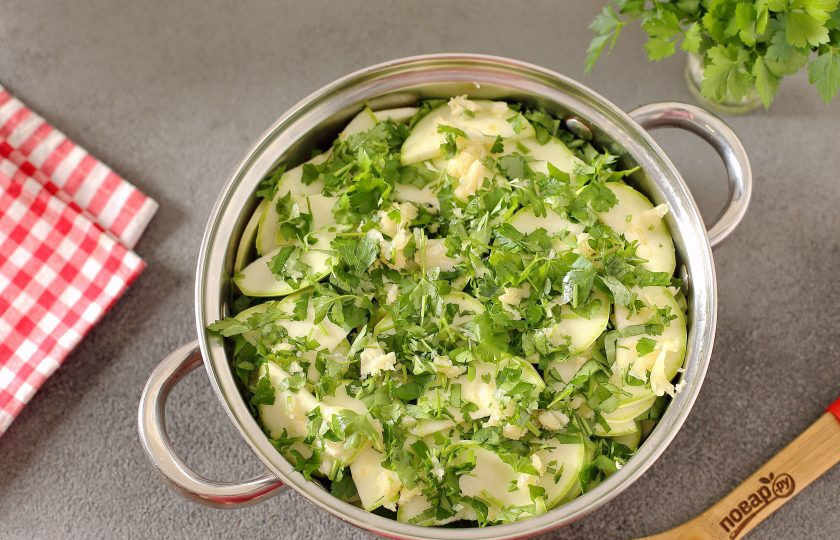 1. Этап. Кабачки Хризантема на зиму: Переложите кабачки, зелень и чеснок слоями в глубокую кастрюлю.