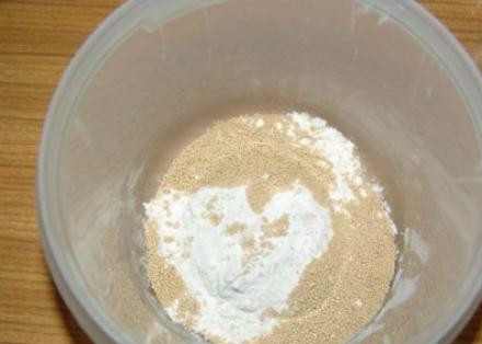 1. Этап. Кулич на дрожжах: Подогрейте воду. С ней смешайте четыре столовые ложки муки и дрожжи. Хорошо перемешайте и уберите на 30 минут в тёплое место.