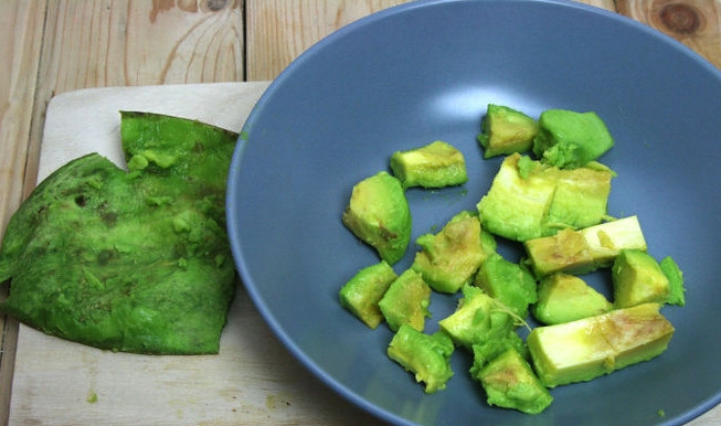 1. Этап. Cалат: авокадо с креветками: Снимите с авокадо шкуруку, аккуратно разрежьте его на две части, доходя до косточки. Затем достаньте косточку и нарежьте авокадо небольшими кубиками. По желанию нарезать его можно и продолговатыми дольками.