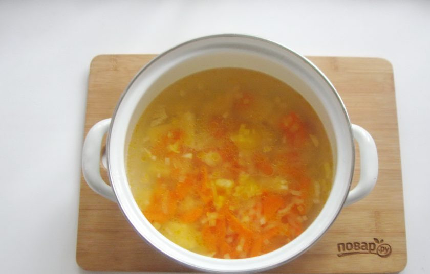 1. Этап. Суп с желтой чечевицей: Лук и морковь выложите в кастрюлю с картофелем и бульоном. Продолжайте варить суп.