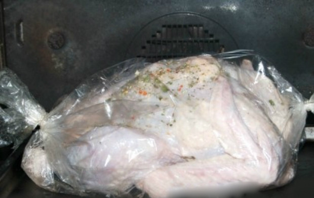 1. Этап. Запеченная индейка в рукаве целиком: 4. Достаньте рукав для запекания, выложите его в форму. Индейку аккуратно заложите в рукав, завяжите открытый край специальным зажимом.