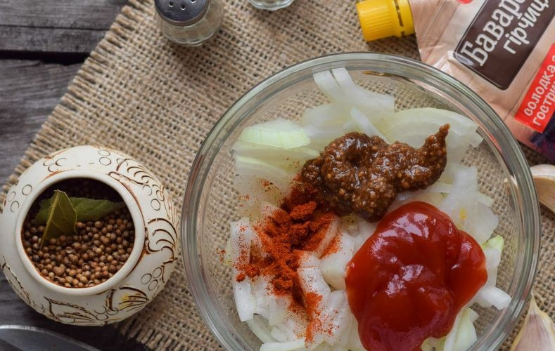 1. Этап. Печень цыплят бройлеров: Добавьте в миску с луком горчицу, кетчуп, паприку, соль и перец. Все тщательно перемешайте и оставьте лук мариноваться на пару часов.