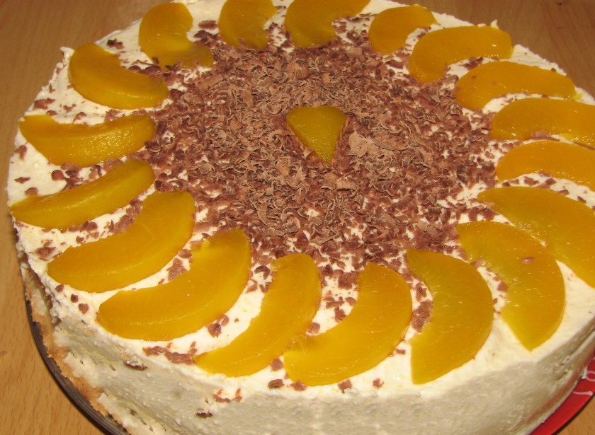 1. Этап. Персиковый торт с маскарпоне: Верхушку нашего тортика обмазываем взбитыми сливками, выравниваем бока ложкой. Украшаем персиками и шоколадом. Оставляем на пару часов в холодильнике. Приятного аппетита!