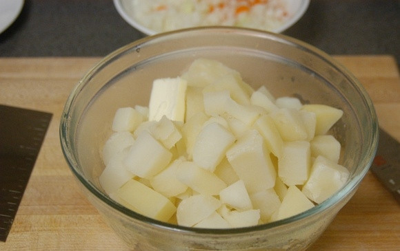 1. Этап. Английский Пастуший пирог классический: 4. Слейте воду с отварного картофеля, оставьте 0,5 стакана воды в кастрюле, добавьте 1 столовую ложку сливочного масла, посолите и поперчите, разомните картофель в пюре.