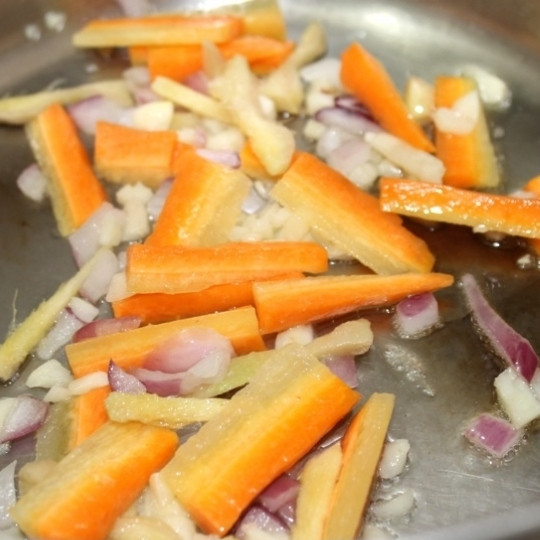 1. Этап. Рамен с курицей: Разогрейте в жаровне масло. Обжарьте произвольно нарезанный лук, морковь, имбирь, чеснок и чили перец.