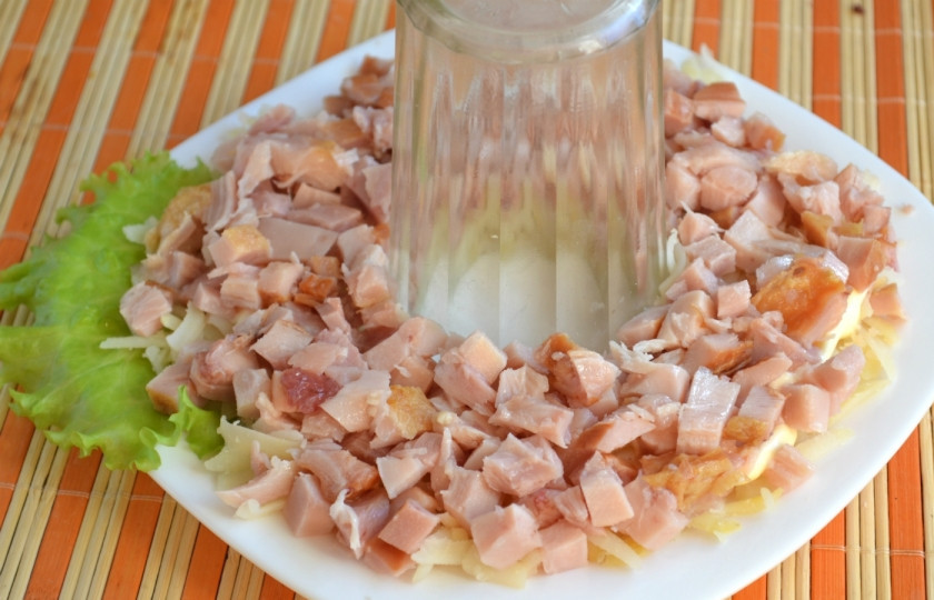 1. Этап. Салат Гранатовый браслет с копченой курицей: Мясо курицы отделите от кости, измельчите и выложите вторым слоем. Сверху смажьте майонезом.