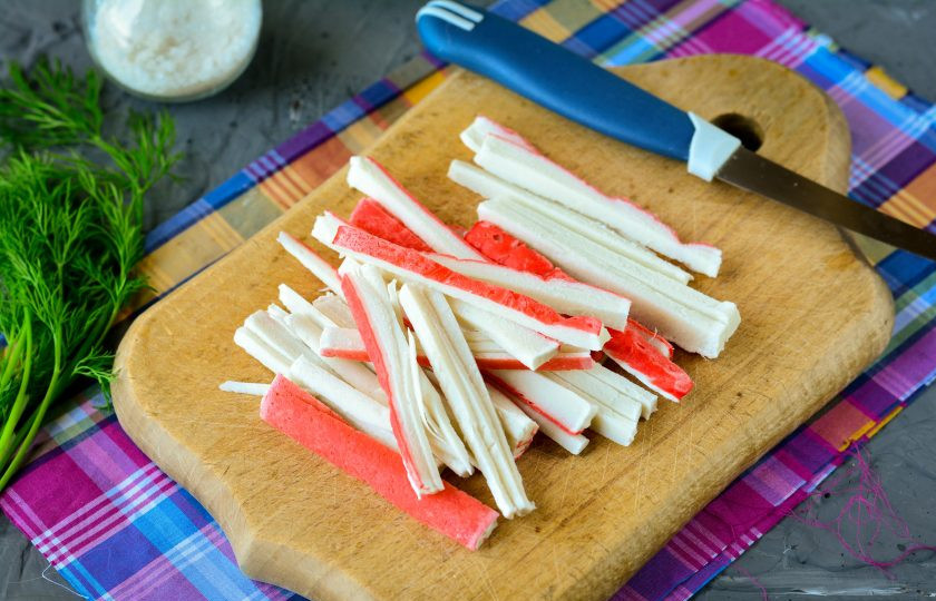 1. Этап. Салат с жареными крабовыми палочками: Размороженные крабовые палочки нарежьте полосками.