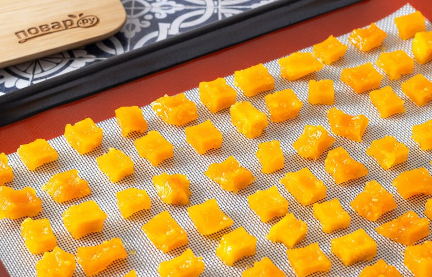 1. Этап. Тыквенные цукаты в духовке: Аккуратно выложите тыквенные кубики на пергамент для выпечки или силиконовый коврик. Разогрейте духовку до 120 градусов и подсушите цукаты около 1 часа. Времени может потребоваться больше или меньше, ориентируйтесь на внешний вид цукатов.