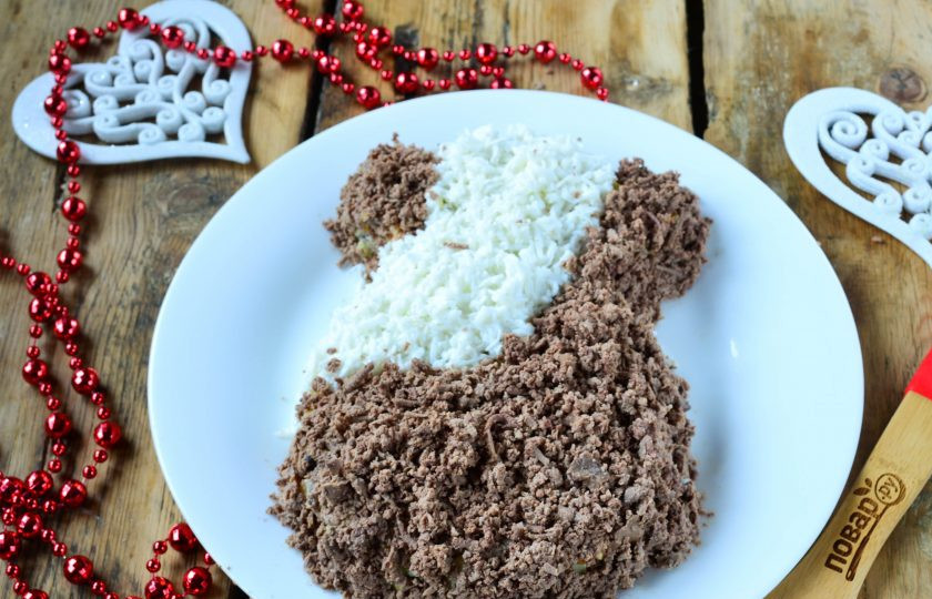 1. Этап. Новогодний салат в Год Собаки: Оставшуюся куриную печень натрите на мелкой терке и обсыпьте этой крошкой весь салат.