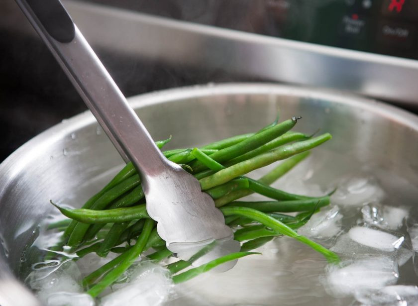 1. Этап. Салат с консервированным тунцом и яйцом: 1. Кастрюлю с водой отправляю на огонь. Параллельно подготавливаю еще миску с ледяной водой и льдом. В закипевшую воду отправляю фасоль, варю её 3 минуты, затем перекладываю фасоль в миску с ледяной водой, чтобы та не потеряла зеленый цвет, затем нарезаю на 3 части.