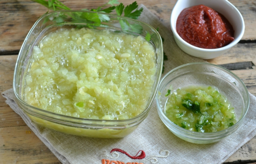 1. Этап. Аджика из кабачков с томатной пастой: Кабачки порежьте кусочками. Пропустите через мясорубку с мелкой решеткой. Стручок горького перца разрежьте пополам, удалите середину с семенами и тоже измельчите в мясорубке и положите в отдельную тарелку.