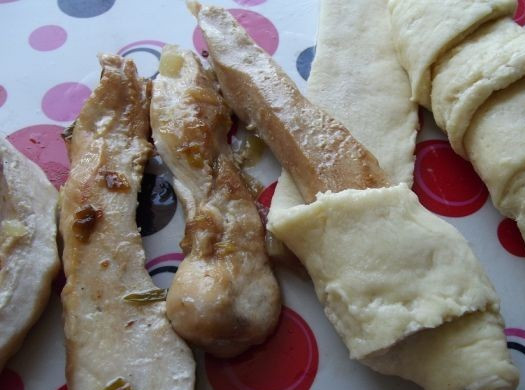 1. Этап. Слойки с курицей: Заворачиваем кусочки курицы в полоски теста, накручивая тесто по диагонали.