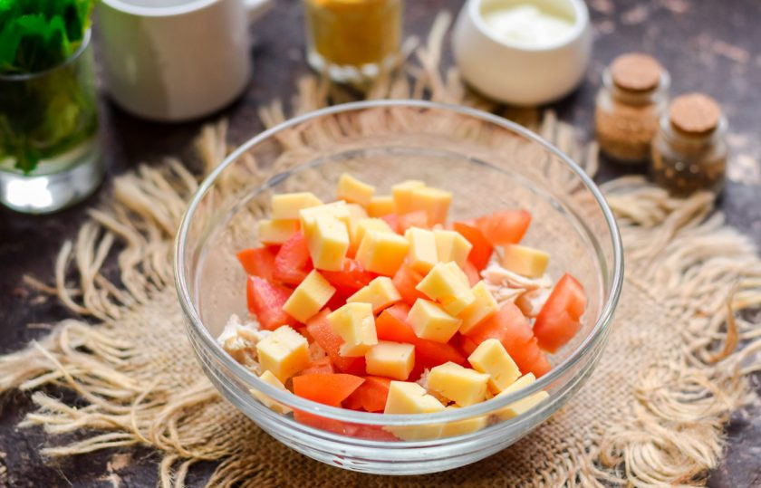 1. Этап. Салат с курицей и помидорами: Нарежьте небольшими кубиками вкусный твердый сыр. Переложите сыр в миску со всеми ингредиентами.