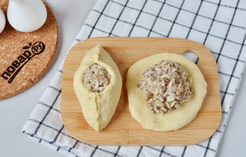 1. Этап. Начинка для расстегаев: Раскатайте шарик теста, выложите 2 полные столовые ложки грибной начинки. С обеих сторон защипните края, оставляя небольшое отверстие по центру.