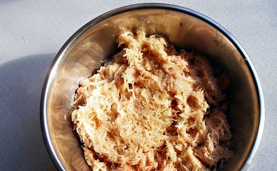 1. Этап. Колдуны с мясом: Почистите картофель и перетрите на мелкую терку. Сложите в кастрюлю.