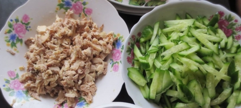 1. Этап. Салат с курицей, и грибами, и огурцами: Отварное куриное филе разбираем на волокна. Огурцы моем, а затем нарезаем тонкими ломтиками.
