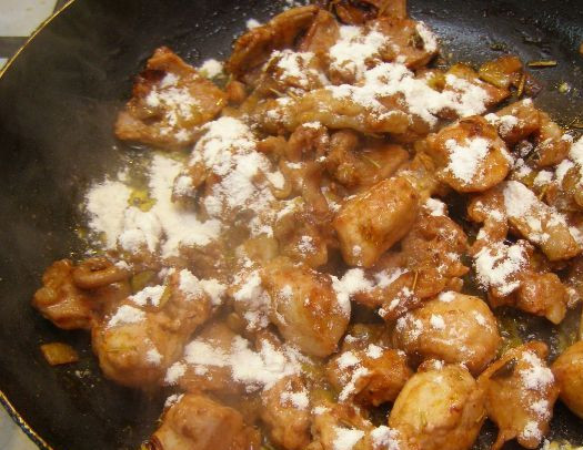 1. Этап. Гуляш из кролика с подливкой: Посыпаем поджарившееся мясо мукой, перемешиваем и жарим минутку.