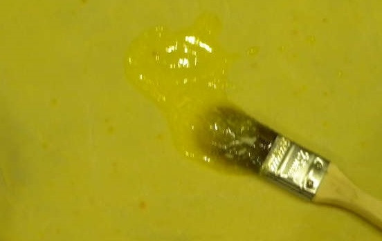 1. Этап. Слоеный пирог с курицей: 2. Оставшееся сливочное масло также растопите и остудите немного. С помощью кисточки тщательно промажьте тесто маслом.