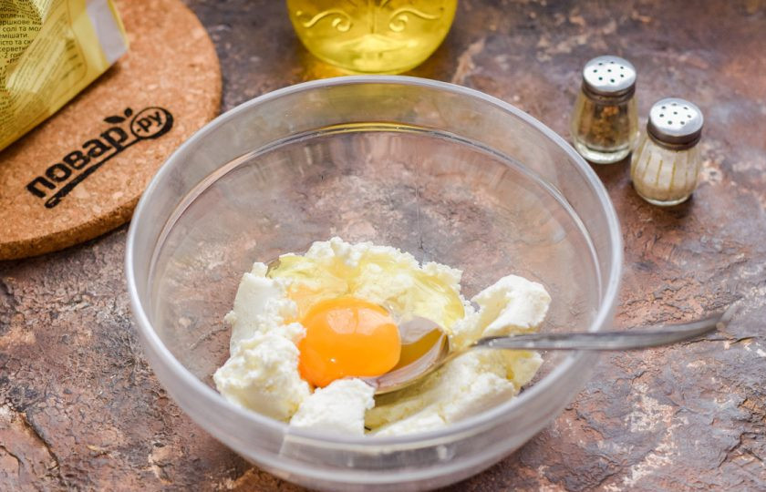 1. Этап. ПП пицца на творожном тесте: В миску выложите творог, добавьте яйцо, всыпьте соль и перец по вкусу.