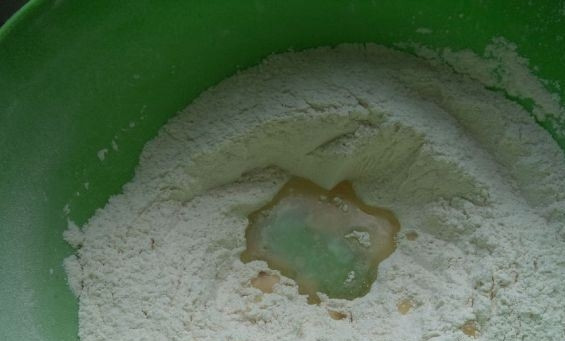1. Этап. Тесто для пирогов с сухими дрожжами: Перемешайте муку с дрожжами. Сделайте в сухих ингредиентах небольшое углубление и влейте в него растительное масло без запаха.