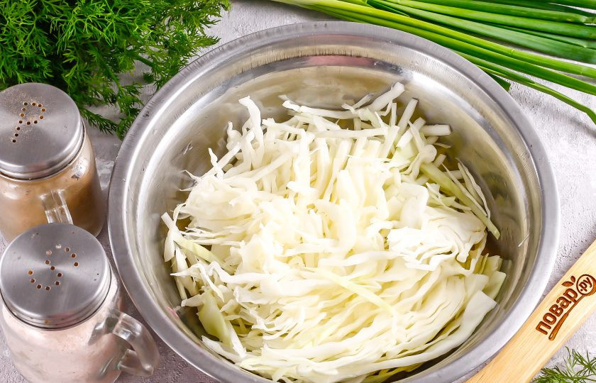 1. Этап. Салат Бело-зеленый: С капусты снимите верхние листья, срежьте необходимую для салата часть и нашинкуйте ее тонкими лентами. Слегка примните всю нарезку, чтобы она выпустила сок и выложите в глубокую емкость.