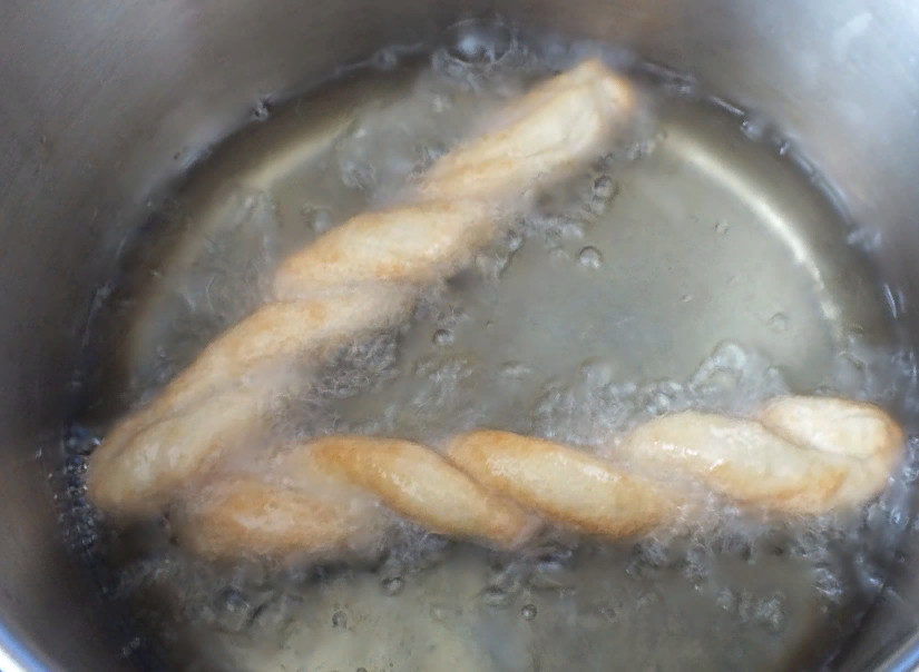 1. Этап. Пилита: Разогрейте растительное масло в кастрюле до легкого дымка, после огонь убавьте. Опускайте в кипящее масло заготовки по две штуки. Важно, чтобы они не соприкасались друг с другом. Обжаривайте до румяной корочки в течение нескольких минут.