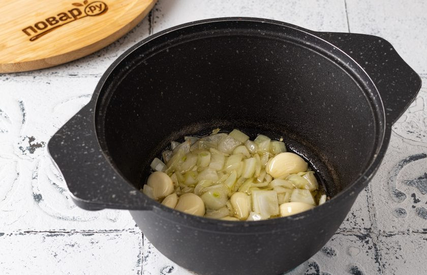 1. Этап. Чесночный суп: Разогрейте оливковое масло в кастрюле с толстым дном. Нарежьте кубиками репчатый лук, зубчики чеснока очистите от шелухи. На средне-низком огне обжарьте их до мягкости около 10 минут.