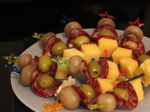 1. Этап. Канапе с колбасой и сыром: 3. Делаем первый вид канапе - с колбасой копченой. Нанизываем на шпажки кубики сыра, оливки, кружочек колбасы и маленький шампиньон в очередности, указанной на фото.